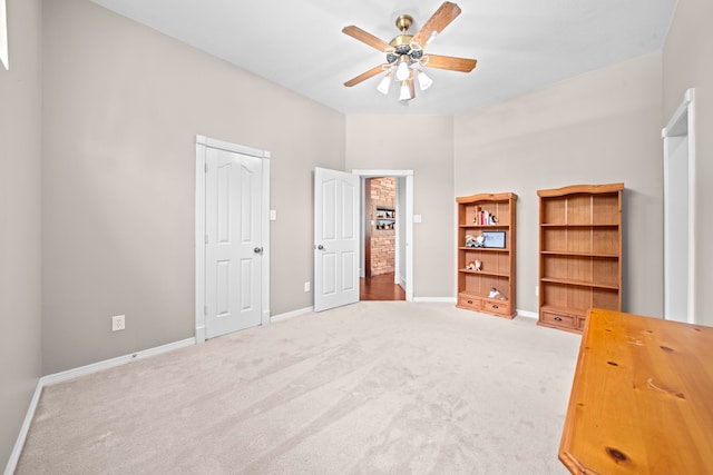 unfurnished bedroom with light colored carpet, baseboards, and ceiling fan