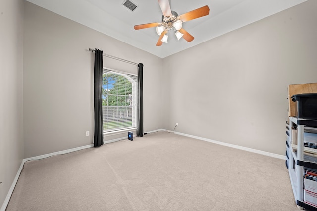 spare room with a ceiling fan, carpet flooring, baseboards, and visible vents