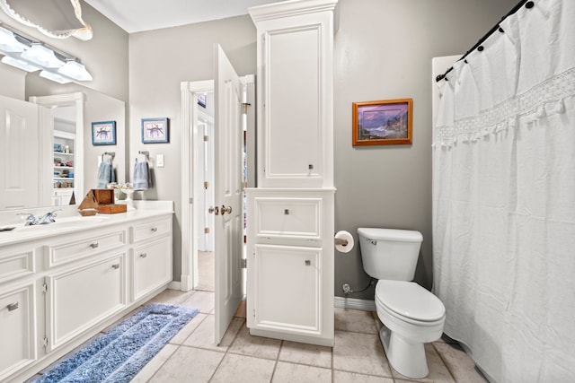 bathroom featuring tile patterned flooring, toilet, vanity, and baseboards