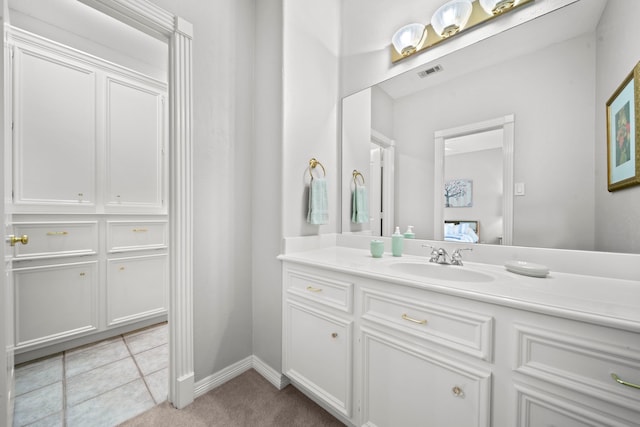 ensuite bathroom with tile patterned floors, visible vents, ensuite bath, baseboards, and vanity