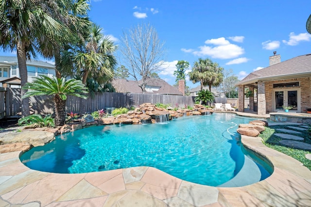 view of swimming pool featuring a patio area, french doors, a fenced in pool, and a fenced backyard