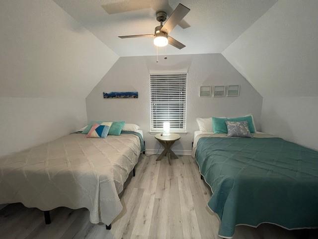 bedroom featuring vaulted ceiling, ceiling fan, and wood finished floors