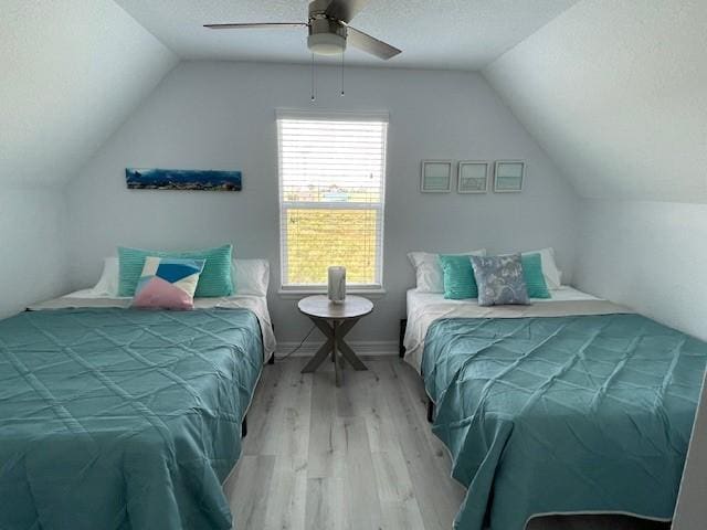 203 Sea Oats Dr, Surfside Beach, TX 77541 - bedroom with vaulted ceiling, a textured ceiling, and wood finished floors