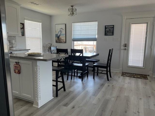 203 Sea Oats Dr, Surfside Beach, TX 77541 - dining space featuring light wood-type flooring, visible vents, and baseboards