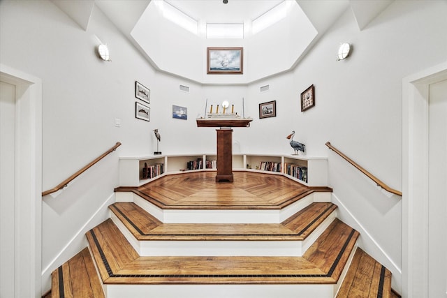 stairs with visible vents, hardwood / wood-style flooring, and baseboards