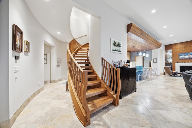 stairs with recessed lighting, stone finish flooring, and baseboards