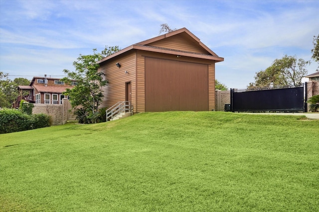 exterior space with a yard, an outdoor structure, fence, and a detached garage