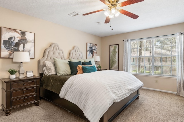 bedroom with a textured ceiling, light carpet, a ceiling fan, visible vents, and baseboards