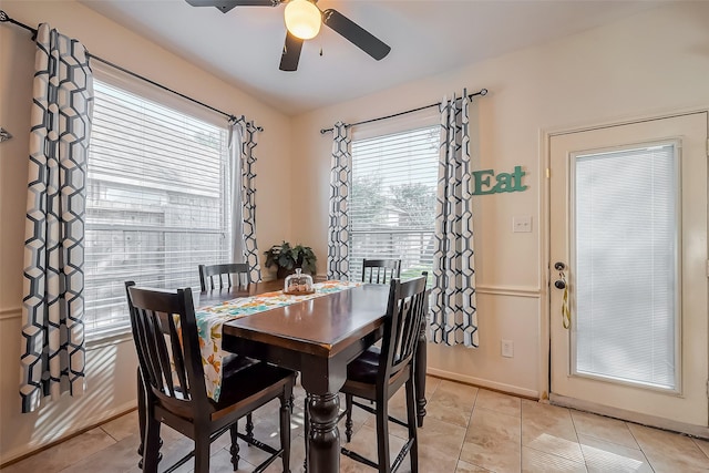 dining area with light tile patterned floors, baseboards, and ceiling fan