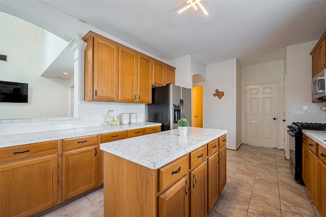 kitchen with brown cabinets, black appliances, backsplash, arched walkways, and light countertops