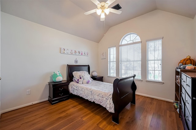 bedroom featuring vaulted ceiling, multiple windows, baseboards, and wood finished floors