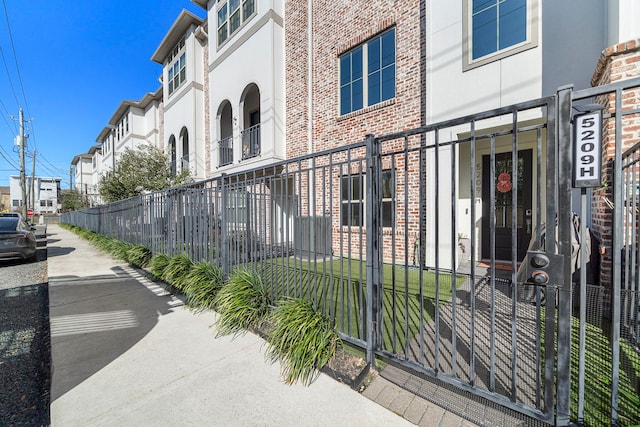 exterior space featuring fence, brick siding, and stucco siding