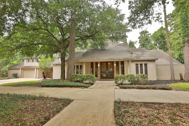 view of front of house with concrete driveway and french doors