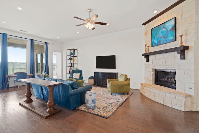 living room featuring recessed lighting, visible vents, ceiling fan, a stone fireplace, and wood finished floors