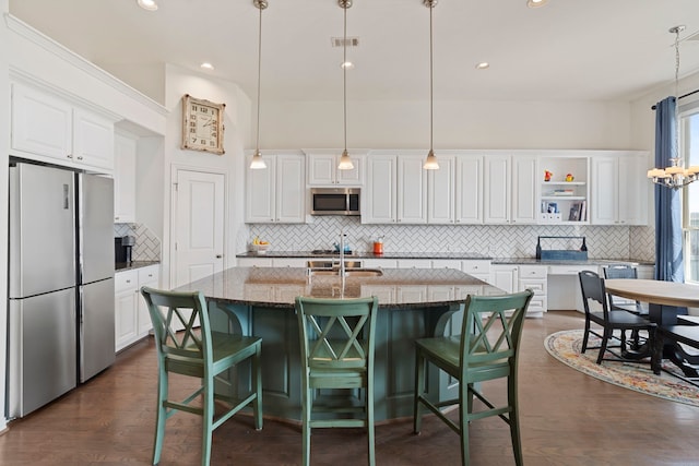 kitchen featuring stainless steel appliances, a sink, visible vents, and white cabinets