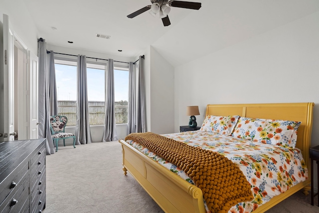 carpeted bedroom with lofted ceiling, visible vents, and a ceiling fan