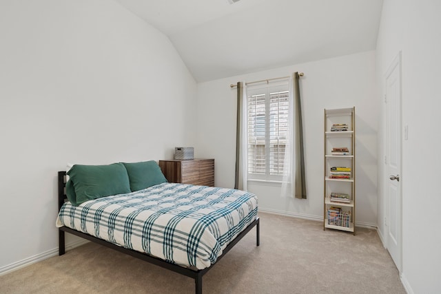 carpeted bedroom with vaulted ceiling and baseboards