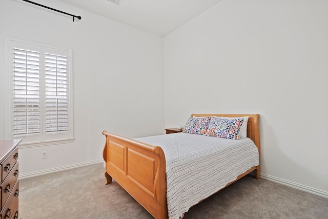 bedroom with light carpet and baseboards