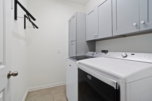 washroom with cabinet space, light tile patterned floors, baseboards, and independent washer and dryer