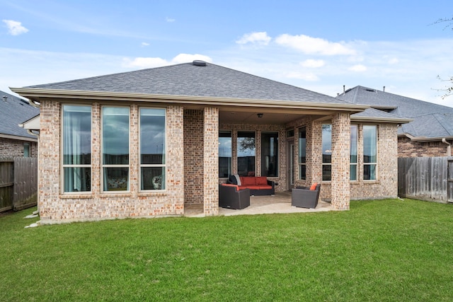 rear view of house featuring fence, an outdoor living space, a lawn, roof with shingles, and a patio area