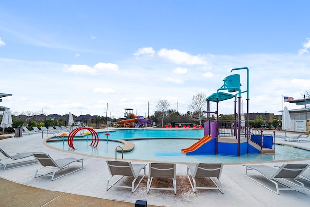 view of pool with playground community, a water slide, and a water play area