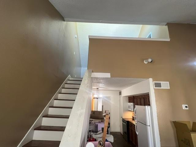 staircase featuring a textured ceiling and visible vents