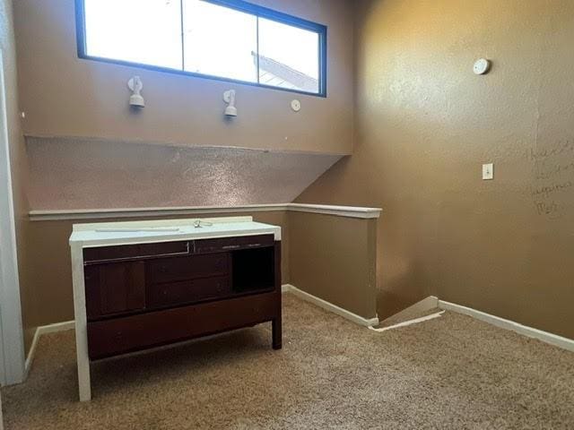 interior space with an upstairs landing, carpet flooring, and baseboards