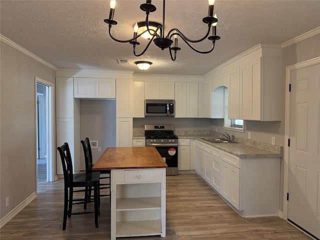 kitchen featuring a chandelier, butcher block countertops, visible vents, appliances with stainless steel finishes, and open shelves