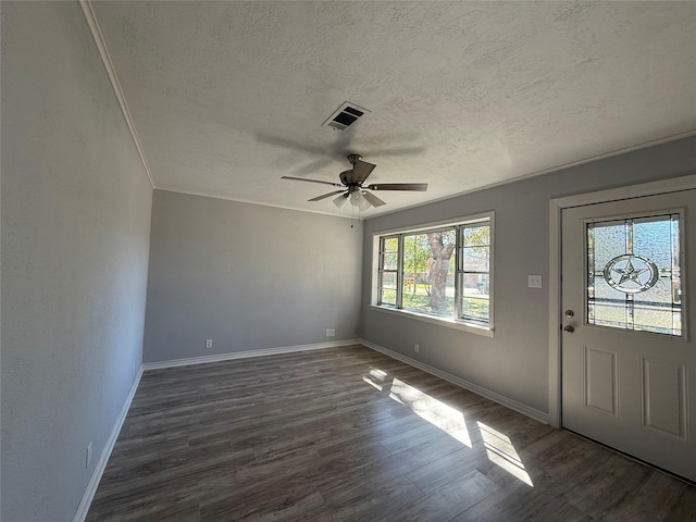 foyer entrance with dark wood-style floors, a textured ceiling, visible vents, and baseboards