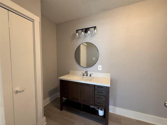 bathroom with wood tiled floor, vanity, and baseboards