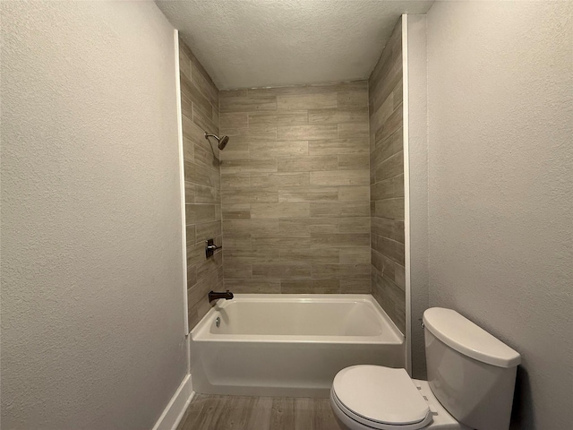 bathroom featuring toilet, a textured ceiling, wood finished floors, and a textured wall