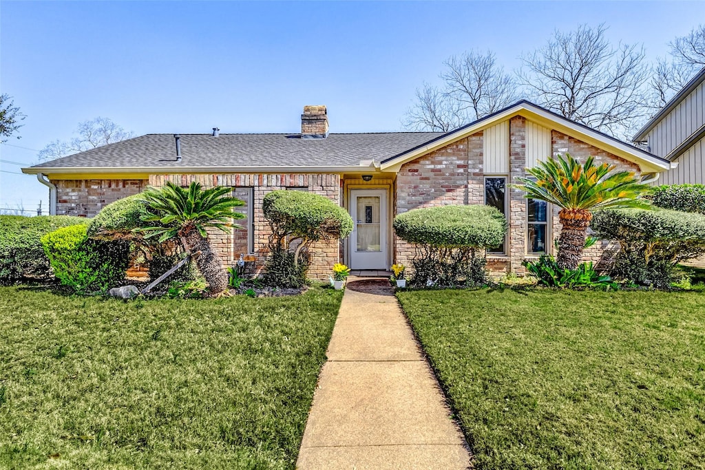 611 Park Knoll Ln, Katy, TX 77450 - view of front of house featuring brick siding, a chimney, a front yard, and a shingled roof