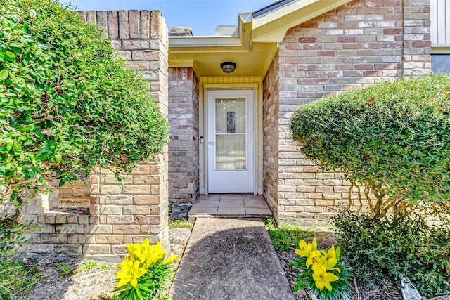 view of exterior entry with brick siding