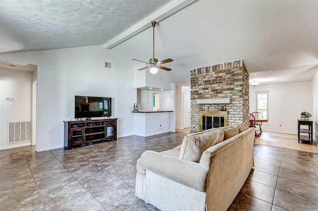 living room featuring baseboards, visible vents, beamed ceiling, and a fireplace