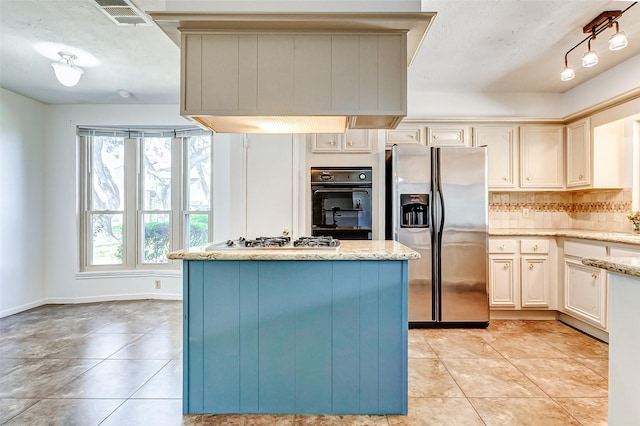 kitchen with appliances with stainless steel finishes, visible vents, decorative backsplash, and light tile patterned floors