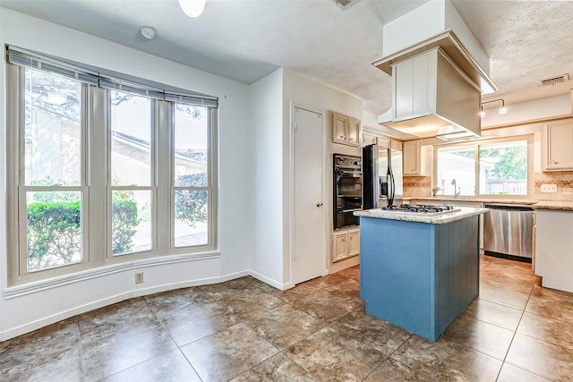 kitchen with stainless steel appliances, a center island, visible vents, baseboards, and decorative backsplash