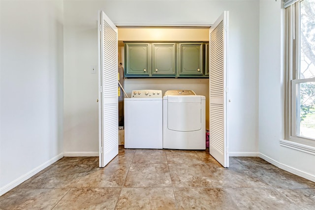 laundry area featuring cabinet space, light tile patterned floors, baseboards, and washing machine and clothes dryer