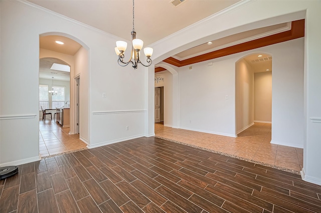 10714 Barker Lake Ct, Cypress, TX 77433 - empty room with a chandelier, wood finish floors, ornamental molding, baseboards, and arched walkways