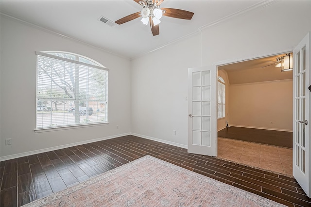 empty room with baseboards, ornamental molding, wood finish floors, and french doors