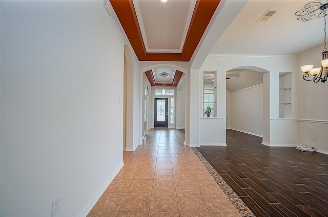 10714 Barker Lake Ct, Cypress, TX 77433 - hall with arched walkways, a chandelier, ornamental molding, baseboards, and a raised ceiling