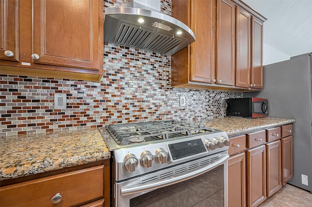 10714 Barker Lake Ct, Cypress, TX 77433 - kitchen with stainless steel appliances, wall chimney range hood, decorative backsplash, and brown cabinetry