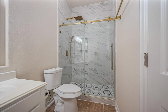 bathroom featuring toilet, a textured wall, a marble finish shower, and vanity