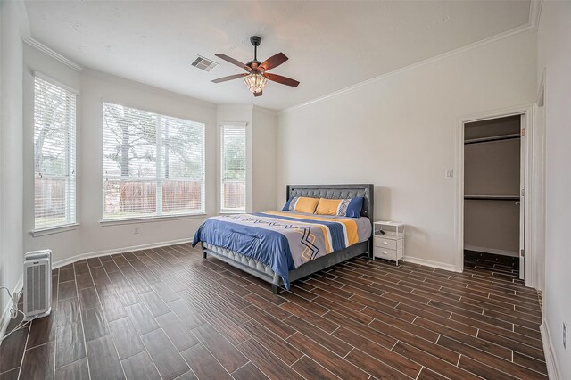 bedroom featuring crown molding, wood finish floors, visible vents, and baseboards