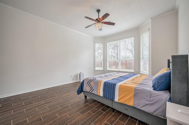 bedroom featuring a ceiling fan, wood tiled floor, crown molding, and baseboards