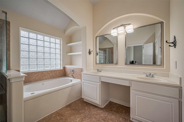 bathroom featuring built in features, double vanity, a sink, tile patterned flooring, and a bath