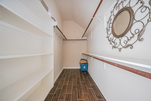 spacious closet with lofted ceiling and wood finish floors