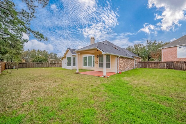 rear view of property with a yard, a patio area, and a fenced backyard