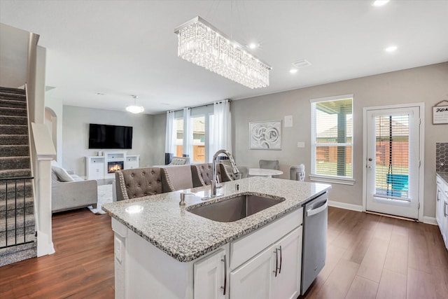 kitchen with dishwasher, dark wood-style floors, a kitchen island with sink, white cabinetry, and a sink