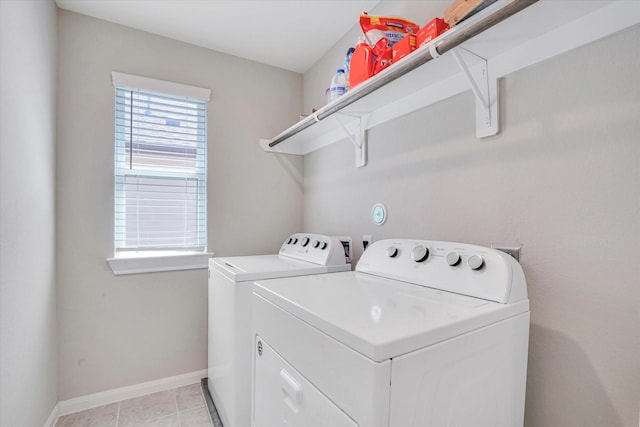 clothes washing area featuring laundry area, washer and clothes dryer, baseboards, and light tile patterned floors