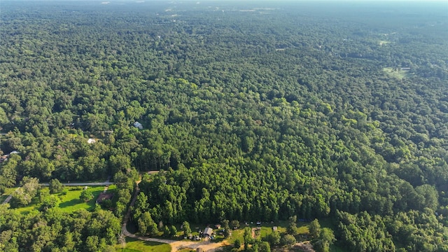 drone / aerial view featuring a wooded view